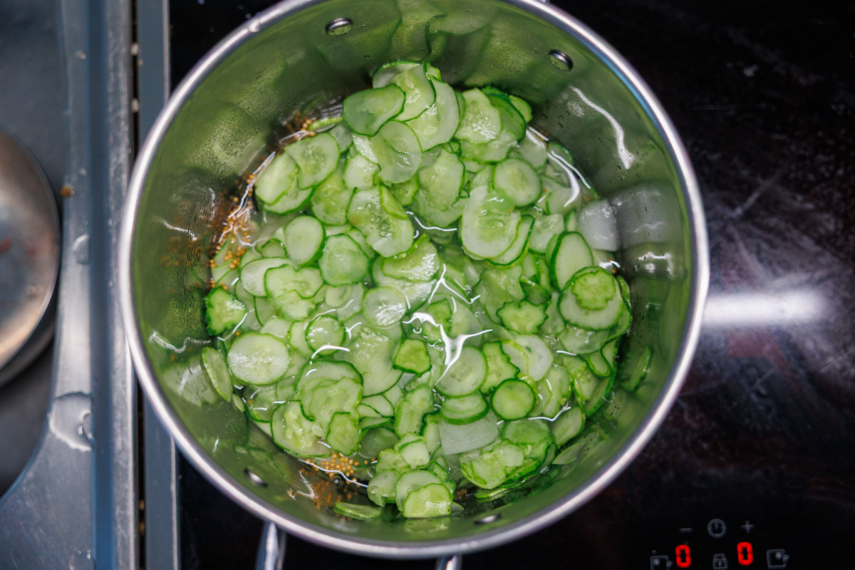 Skivad gurka värms i den kryddade lagen